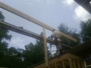 Carpenter setting a ridge beam over a new addition frame — Ice Dam Removal by Roofing Brothers in Arlington Heights