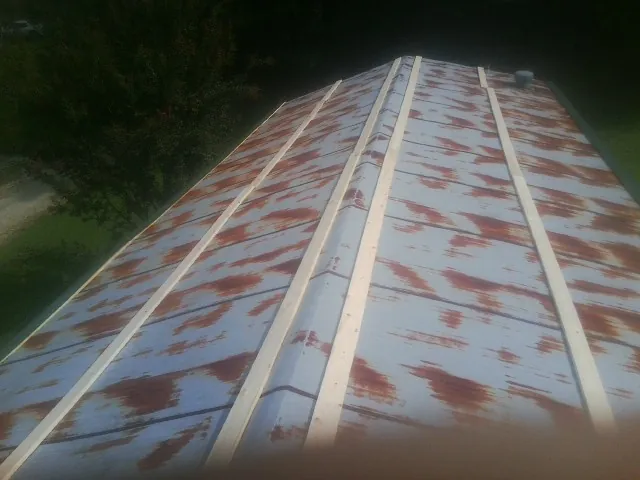 Rusted metal roof panels with new wood purlins before replacement — Storm Damage Roof Repair in Arlington Heights by Roofing Brothers